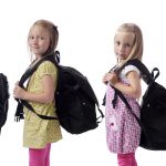 back to school. children in a row with backpacks
